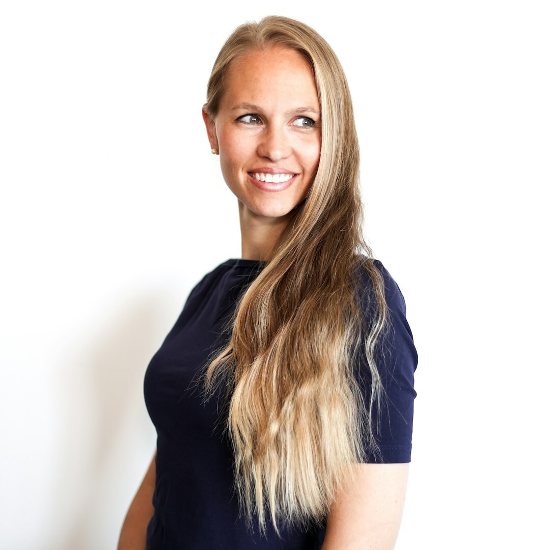 Studio portrait of a young woman with straight hair smiling