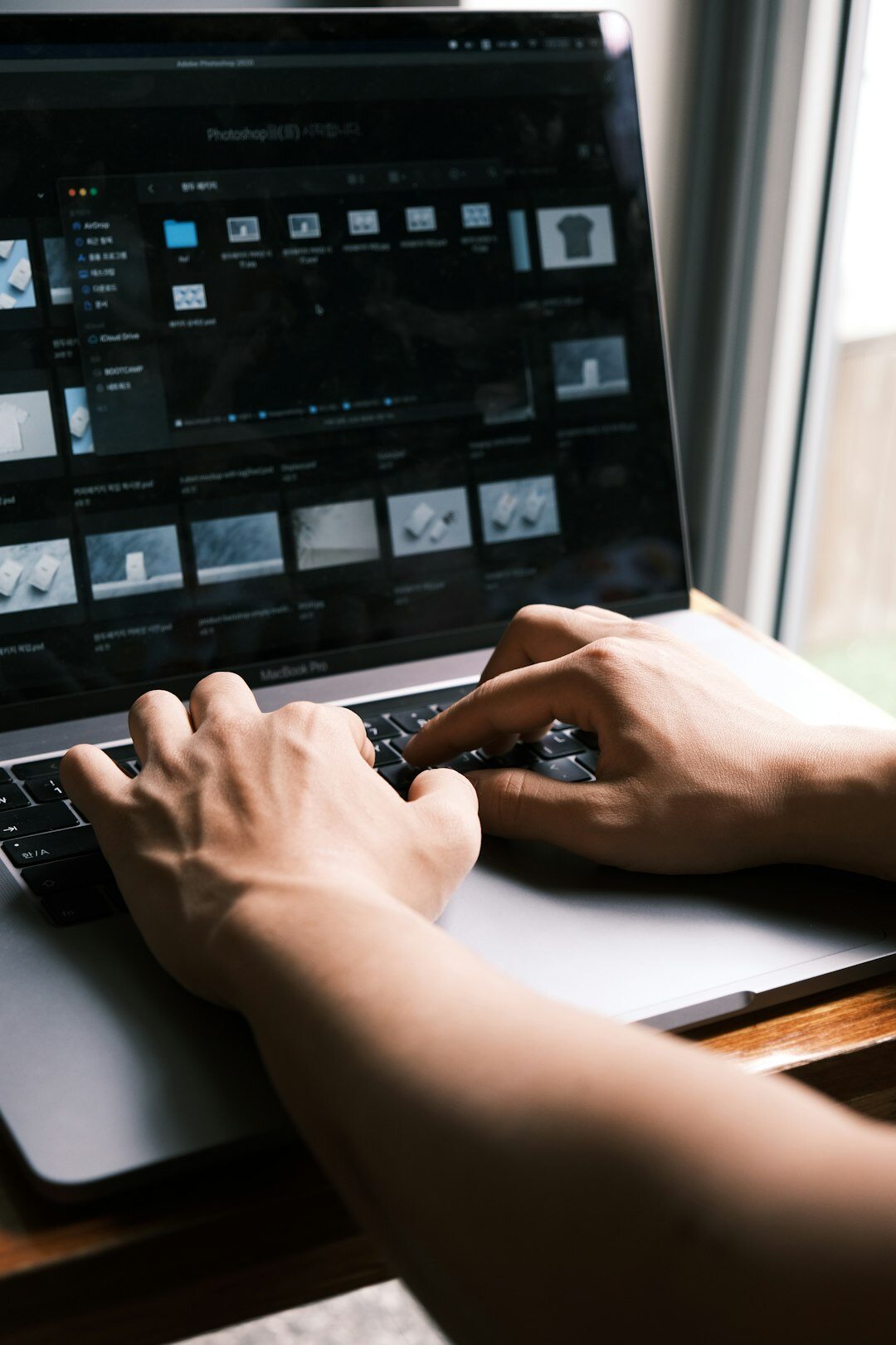 Hands operating a video editing console with monitors showing footage